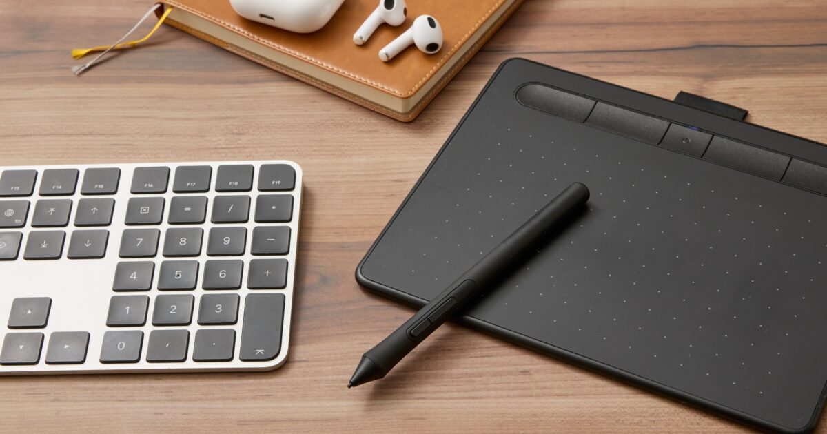 ペンタブレットとワイヤレスイヤホンとキーボードが並ぶデスク